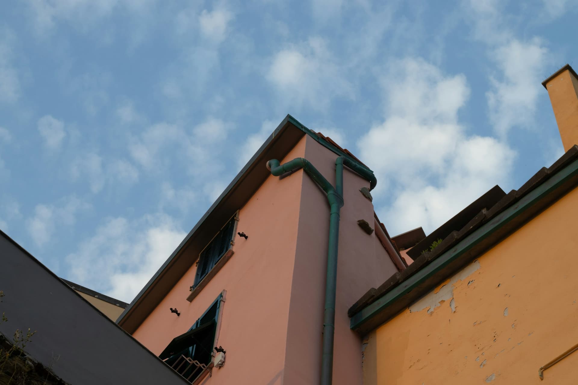 Gouttière et descente d'eaux pluviales sur la façade d'une maison ancienne